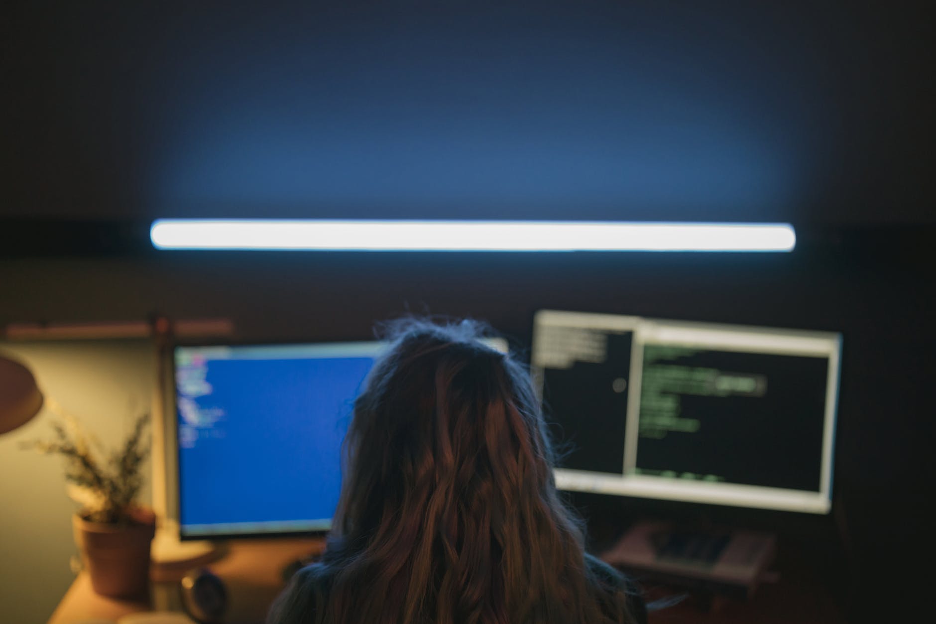 woman in black shirt sitting in front of computer monitor